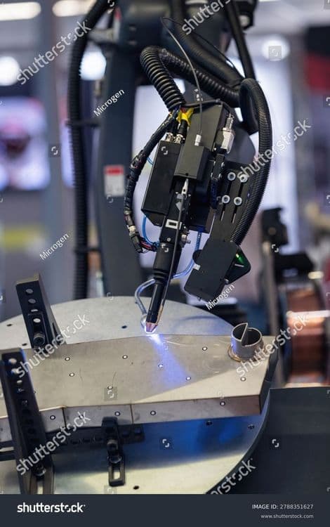 stock-photo-precision-robotic-laser-welding-arm-operates-on-a-large-circular-metal-turntable-with-visible-blue-2788351627.jpg